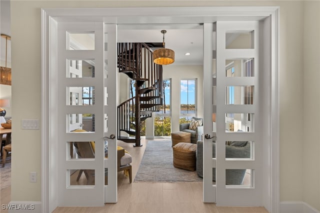 entryway featuring stairway, wood finished floors, and baseboards