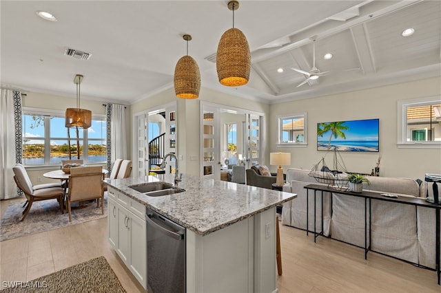 kitchen featuring a sink, white cabinets, open floor plan, light wood-style floors, and stainless steel dishwasher