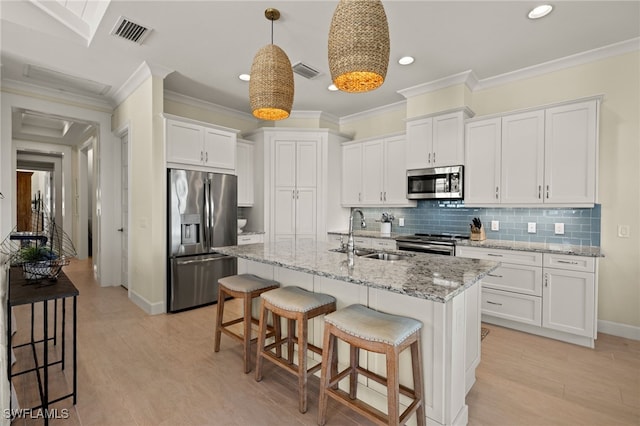 kitchen featuring visible vents, appliances with stainless steel finishes, decorative backsplash, and a sink