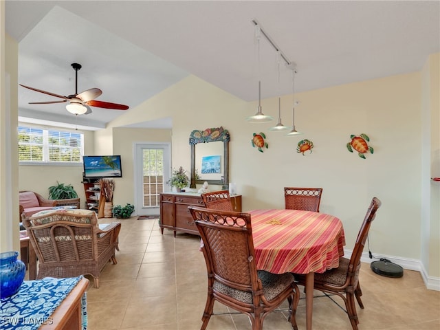 tiled dining room with rail lighting, ceiling fan, and vaulted ceiling