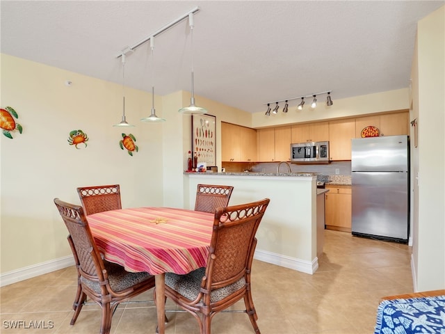 dining area featuring a textured ceiling and light tile patterned floors