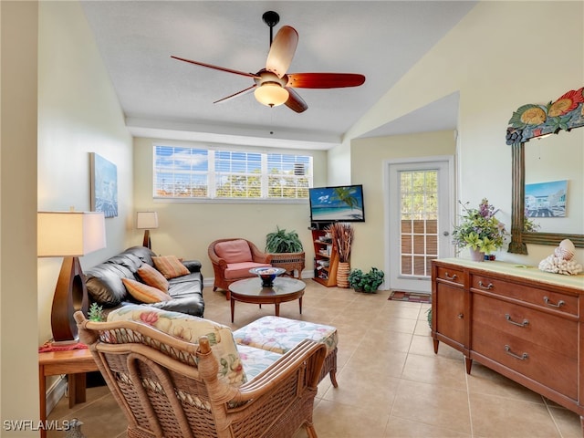 living area featuring vaulted ceiling, ceiling fan, and light tile patterned floors