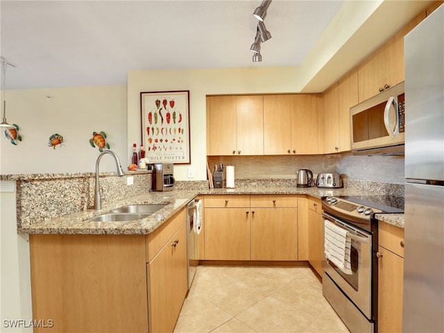 kitchen with sink, kitchen peninsula, appliances with stainless steel finishes, and light brown cabinets