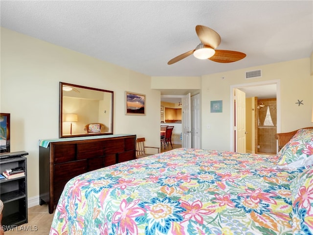 tiled bedroom featuring ceiling fan and a textured ceiling