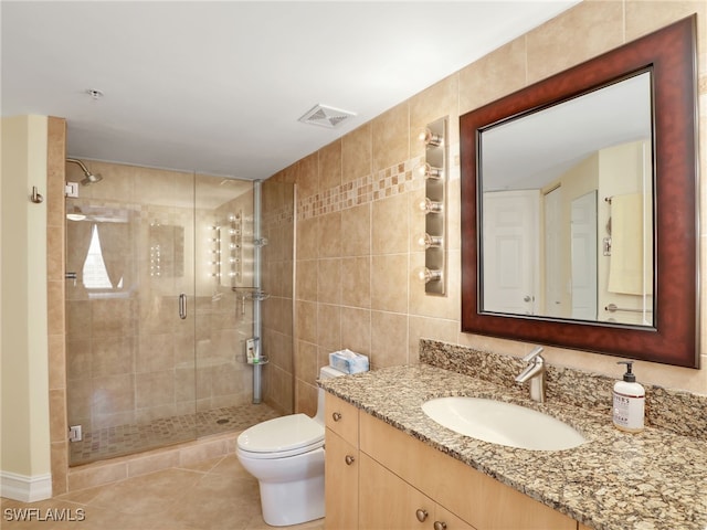 bathroom featuring tile walls, vanity, an enclosed shower, tile patterned flooring, and toilet