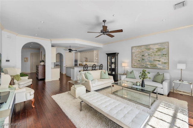 living area featuring a ceiling fan, arched walkways, ornamental molding, hardwood / wood-style flooring, and recessed lighting