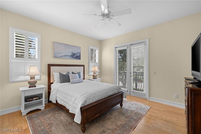 bedroom featuring access to outside, multiple windows, and baseboards