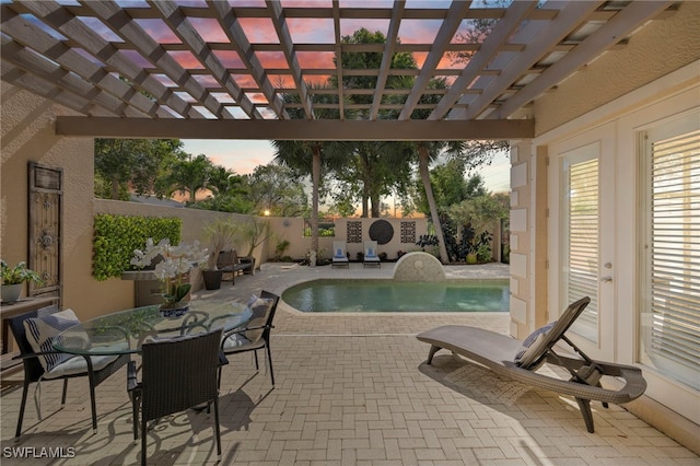 pool at dusk with a fenced backyard, a pergola, and a patio