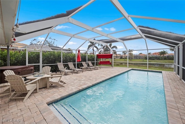 outdoor pool featuring a hot tub, glass enclosure, and a patio area