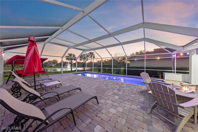 pool featuring a patio, an outdoor fire pit, and glass enclosure