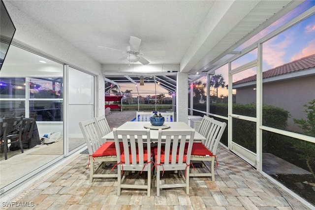 sunroom with a ceiling fan and outdoor dining area