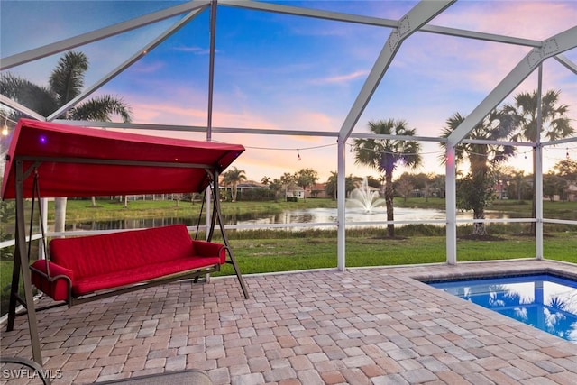view of patio with a water view, a lanai, and an outdoor pool