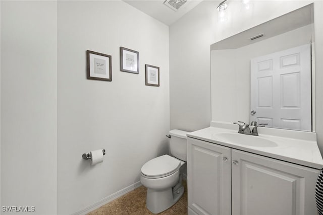 half bathroom featuring baseboards, visible vents, toilet, and vanity