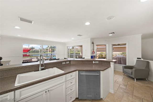 kitchen featuring visible vents, dark countertops, recessed lighting, a sink, and stone tile floors