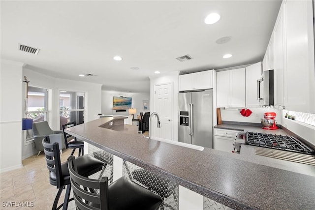 kitchen featuring high end fridge, dark countertops, and visible vents