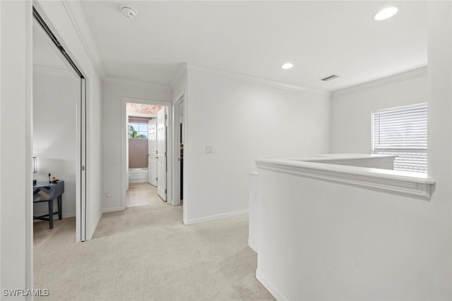 corridor with visible vents, crown molding, baseboards, recessed lighting, and light carpet