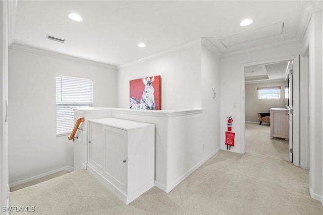 hall featuring baseboards, visible vents, crown molding, and attic access