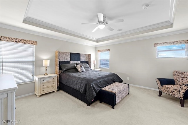 bedroom with a raised ceiling, baseboards, multiple windows, and light colored carpet