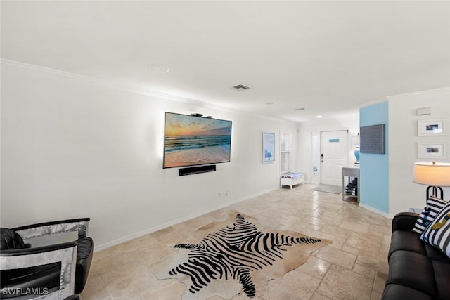 living area featuring baseboards, ornamental molding, visible vents, and stone tile flooring