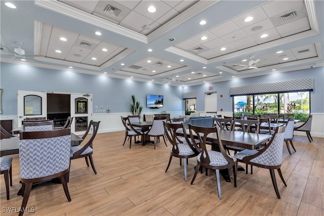 dining area with light wood-type flooring, ornamental molding, and visible vents