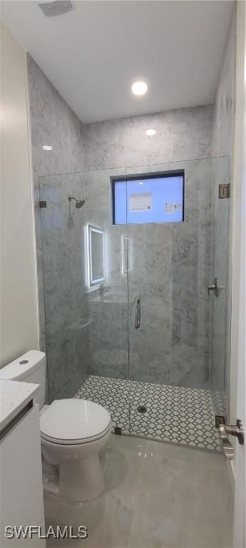 bathroom with toilet, a shower stall, visible vents, and vanity