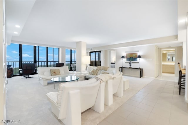 living area with expansive windows, light carpet, and light tile patterned flooring