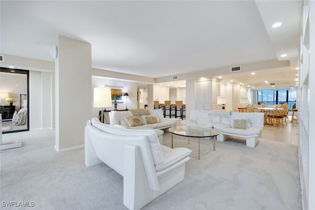 living area with recessed lighting, visible vents, baseboards, and light colored carpet