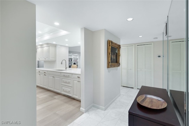 hall featuring recessed lighting, marble finish floor, a sink, and baseboards