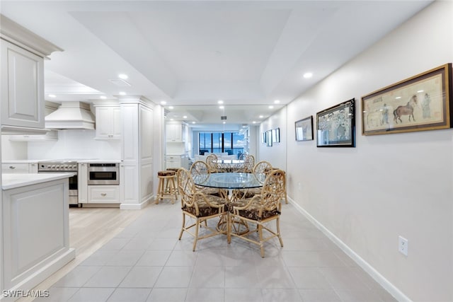 dining room featuring baseboards, light tile patterned floors, a raised ceiling, and recessed lighting