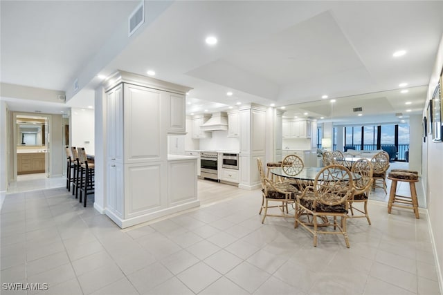 dining space featuring recessed lighting, visible vents, a tray ceiling, and light tile patterned flooring