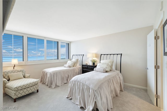 bedroom with baseboards and light colored carpet