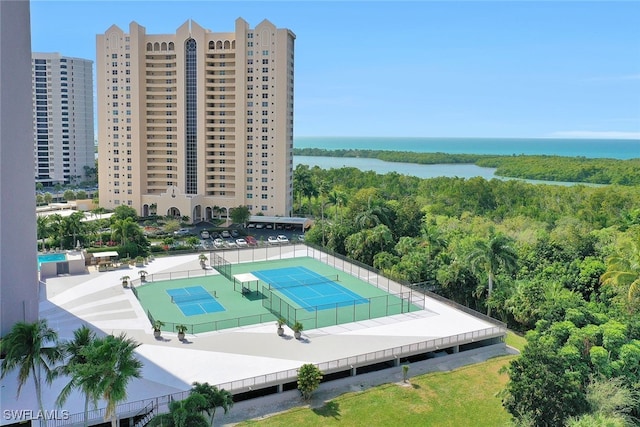 view of pool with a tennis court, a view of city, a water view, and fence