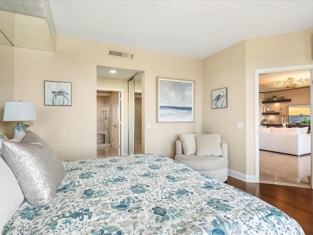 bedroom featuring wood finished floors, visible vents, and baseboards