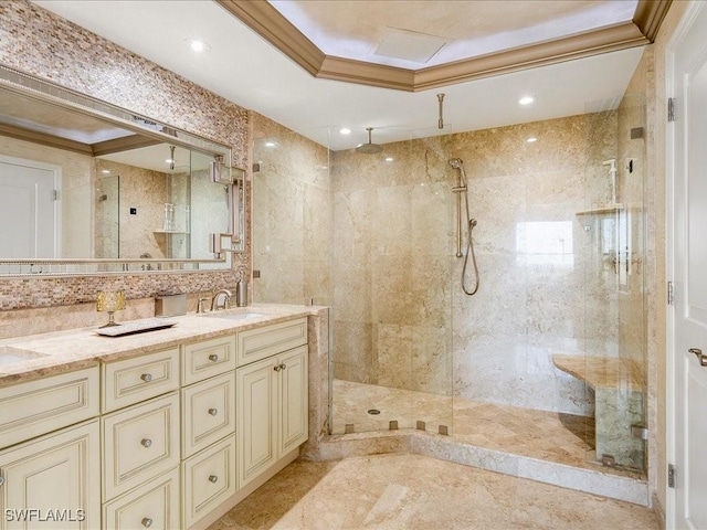 bathroom featuring a stall shower, crown molding, a sink, and double vanity