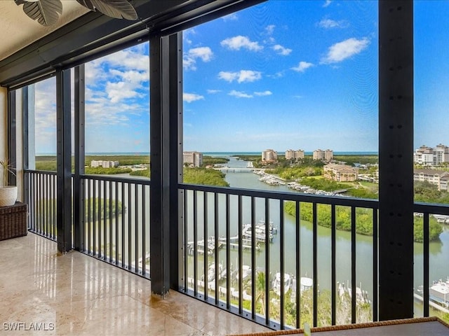 balcony featuring a water view, ceiling fan, and a view of city