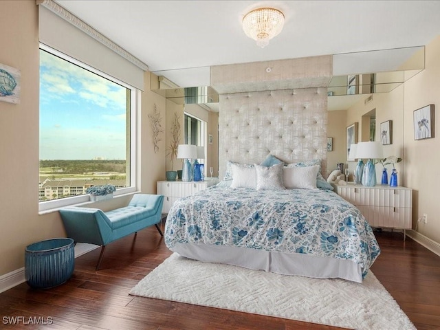 bedroom with dark wood finished floors and baseboards