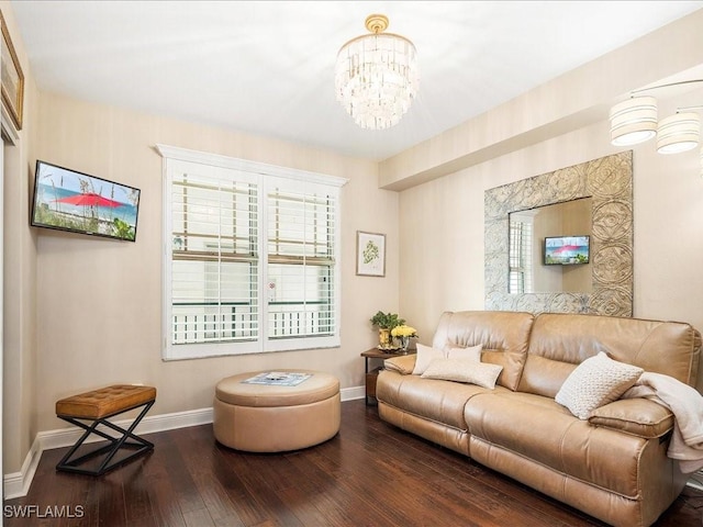 living room with a notable chandelier, baseboards, and wood finished floors