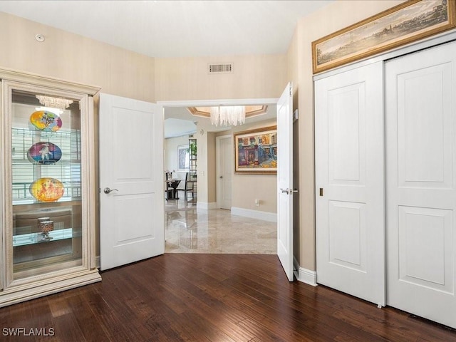 foyer featuring baseboards, visible vents, and dark wood-type flooring