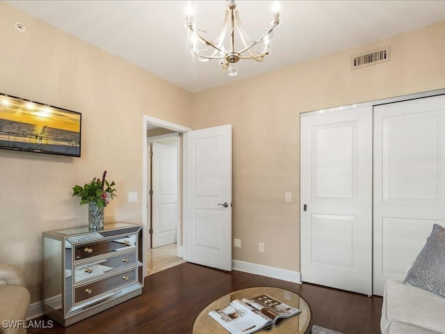 living area featuring a chandelier, visible vents, dark wood finished floors, and baseboards