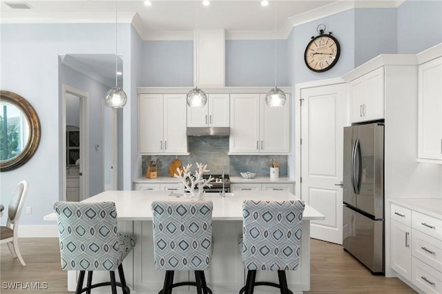 kitchen with freestanding refrigerator, light countertops, and decorative light fixtures