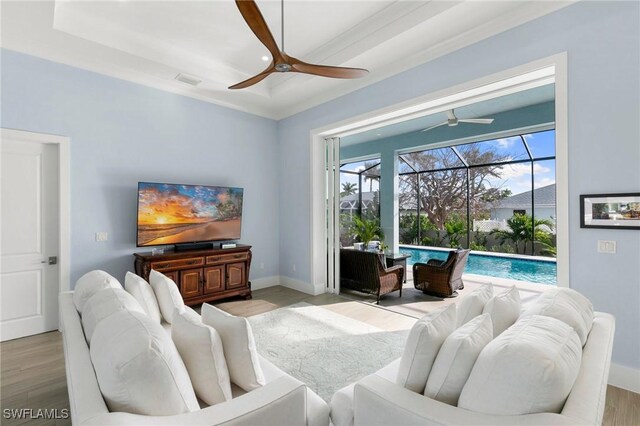 living area with ceiling fan, light wood-type flooring, a sunroom, and baseboards