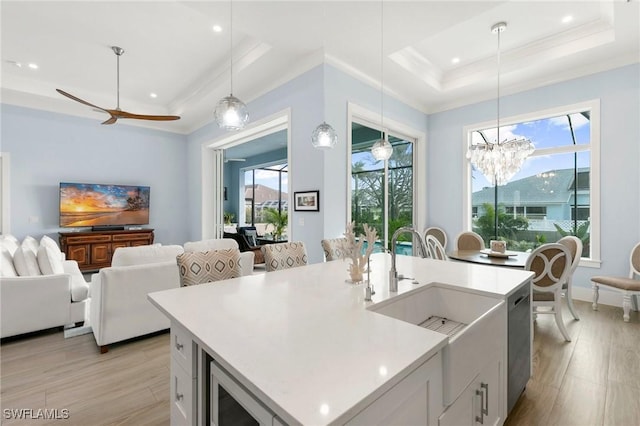 kitchen with pendant lighting, light countertops, a tray ceiling, and white cabinets