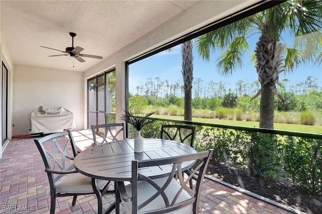 sunroom featuring a ceiling fan