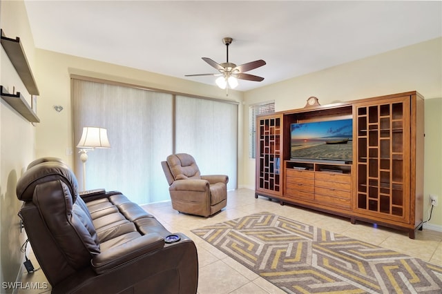 living area with tile patterned floors, a healthy amount of sunlight, and a ceiling fan