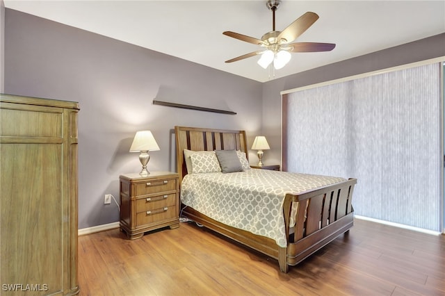 bedroom featuring a ceiling fan, baseboards, and wood finished floors