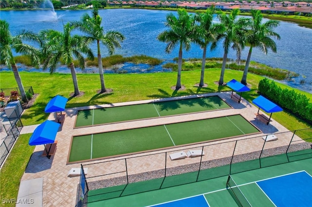 view of home's community featuring a yard, fence, and a water view