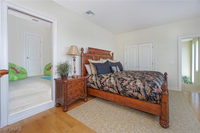 bedroom featuring light wood-style floors, a closet, and visible vents