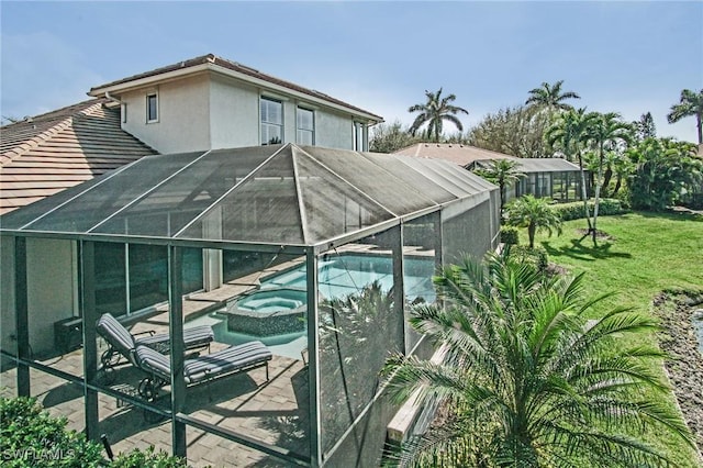 view of swimming pool with a lanai, a patio area, a pool with connected hot tub, and a yard