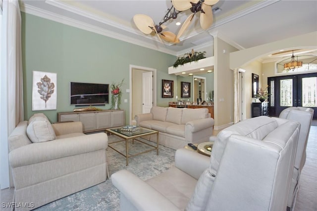 living area with ornamental molding, arched walkways, french doors, and ornate columns