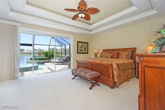 bedroom featuring a tray ceiling, light colored carpet, a water view, a sunroom, and access to outside